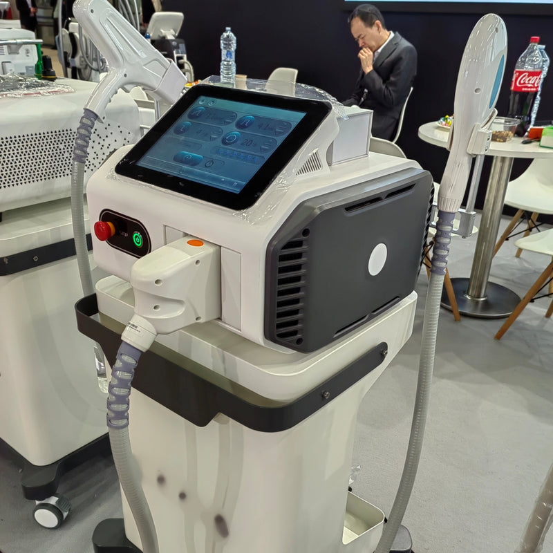 Pilkas ir baltas IPL fotoepiliatorius su matoma vandens aušinimo sistema ties antgaliu ir šoniniu kabeliu